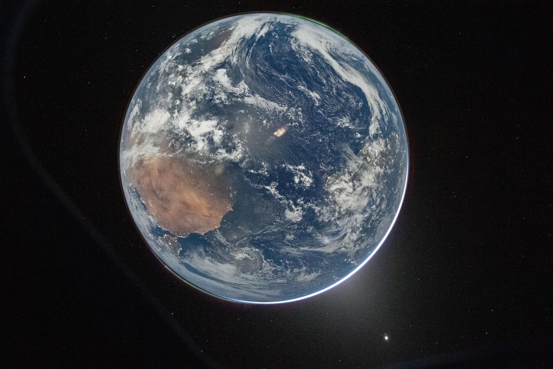 Earth photographed from the Orion spacecraft showing the Sahara, cloud formations, and atmospheric glow
