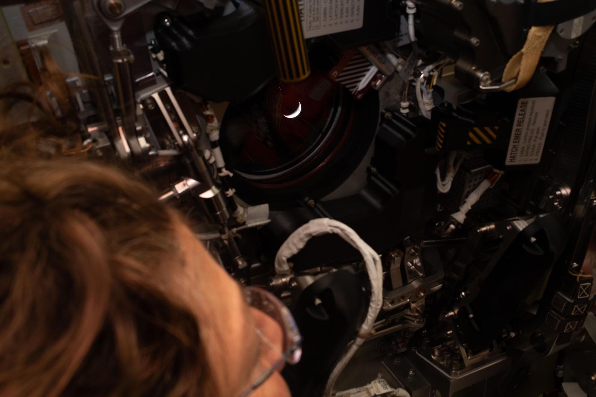 Astronaut Christina Koch views the Moon through a window aboard the Orion spacecraft